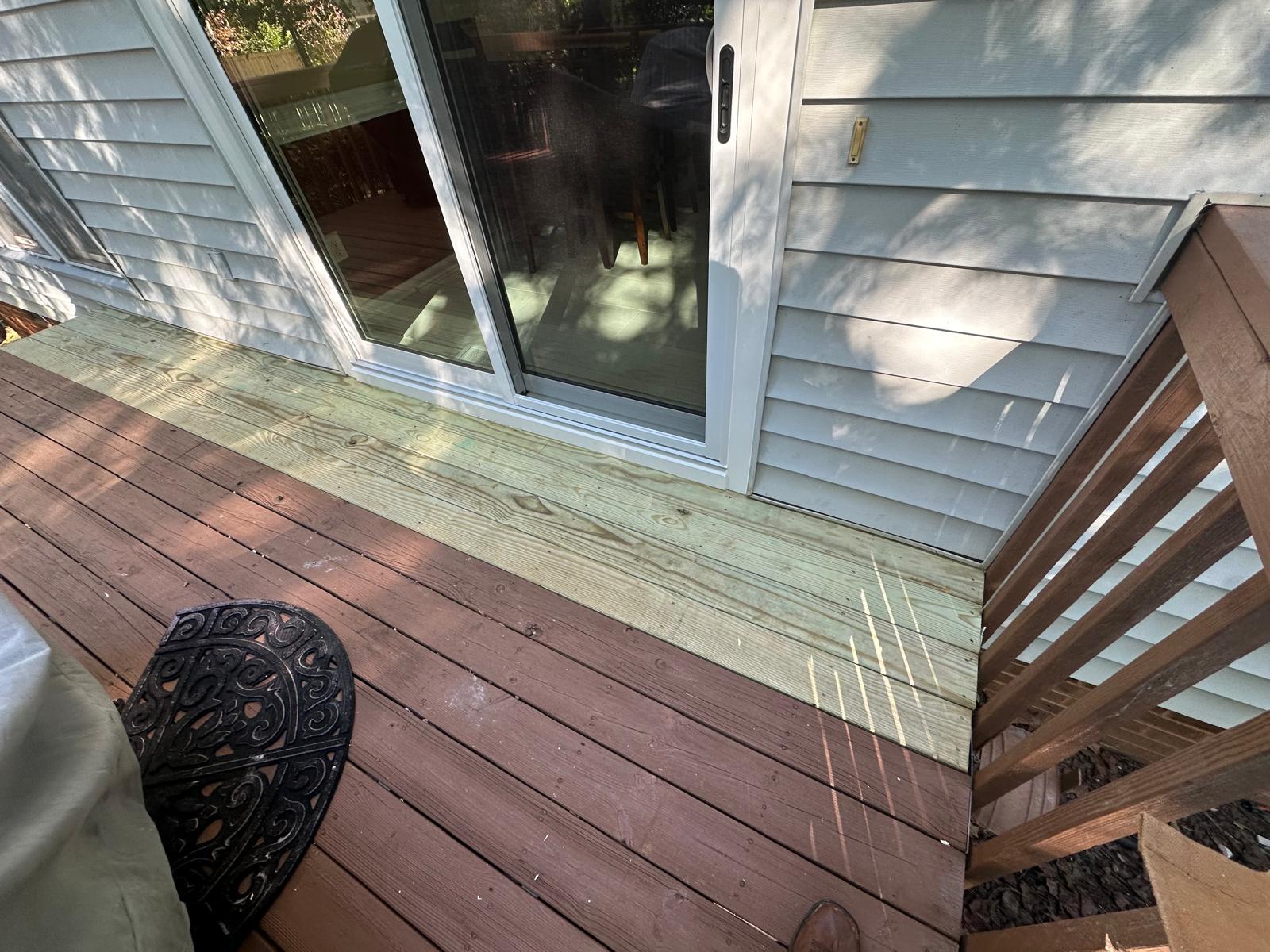 Finished white sliding patio door opening onto a wood deck
